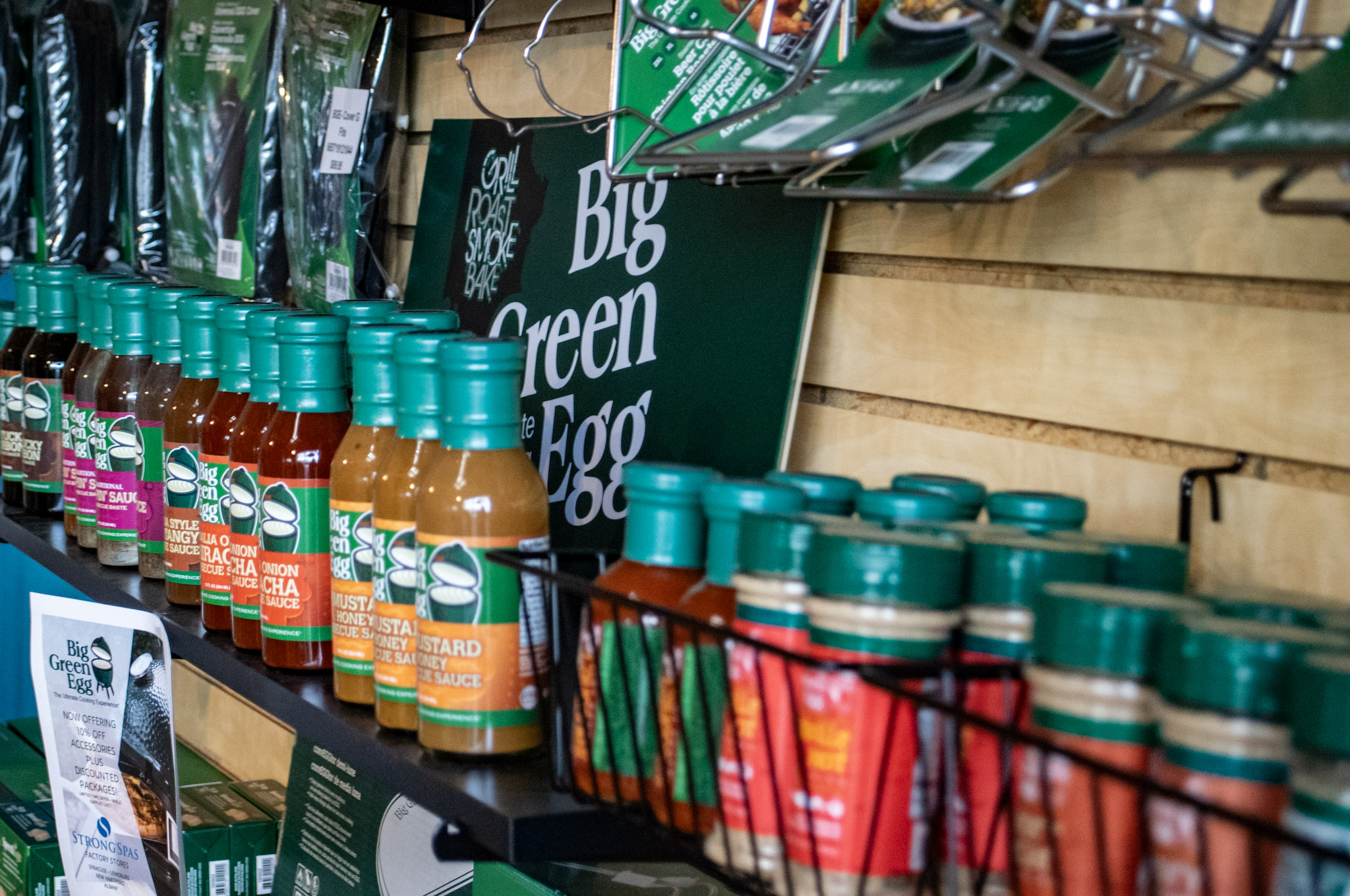 Wall of Big Green Egg seasoning and accessories